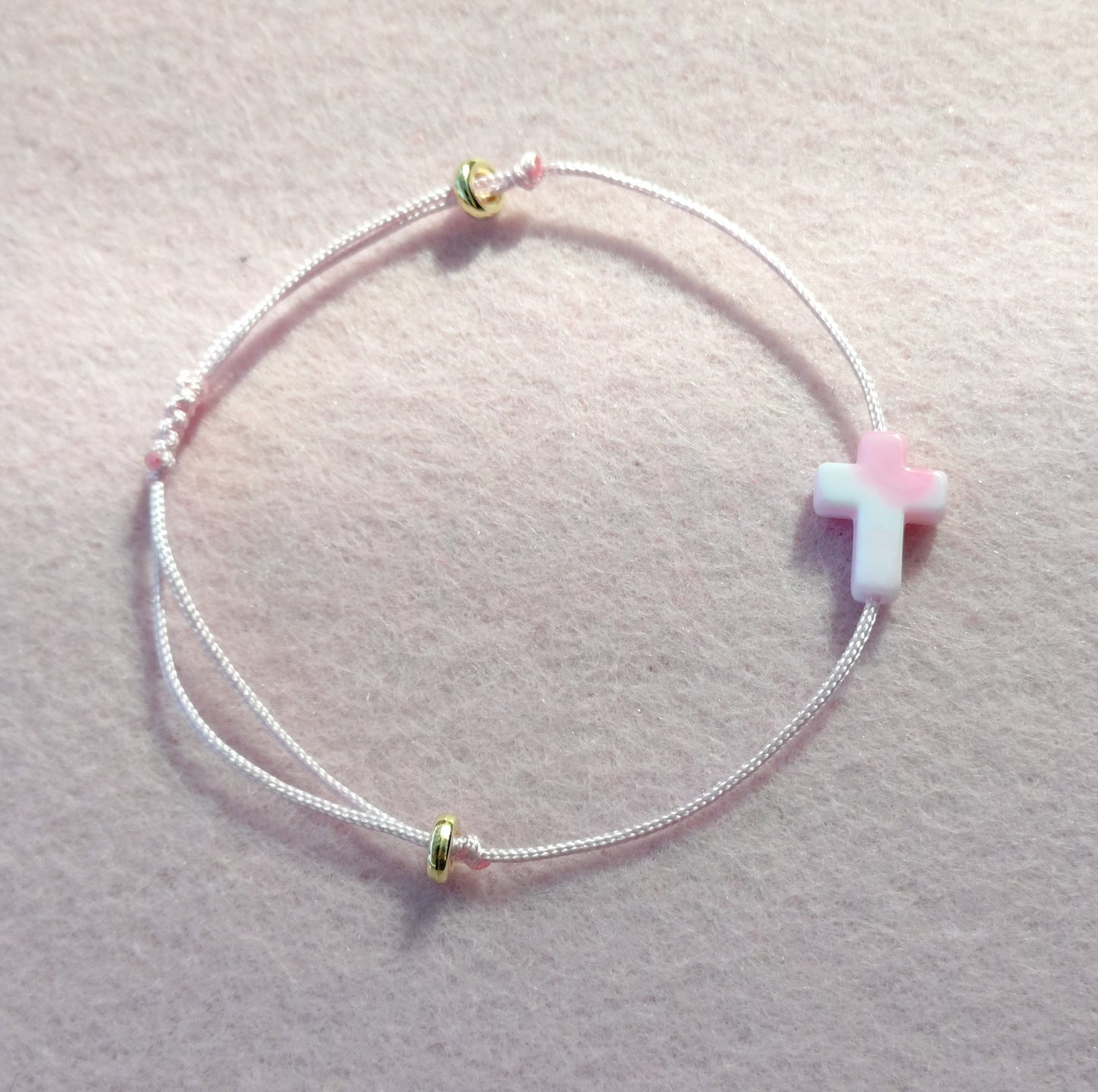 Lyserosa makramé-armbånd med kors